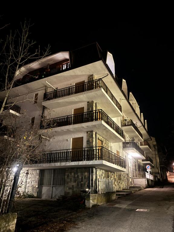 wysoki biały budynek w nocy z ulicą w obiekcie Maison Seguret, respiro montagna w mieście Oulx