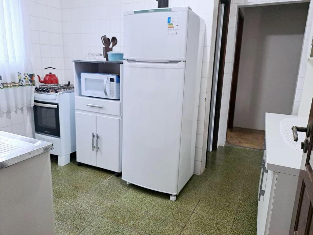 kuchnia z białą lodówką i kuchenką mikrofalową w obiekcie Vento e Vida w mieście São Francisco do Sul