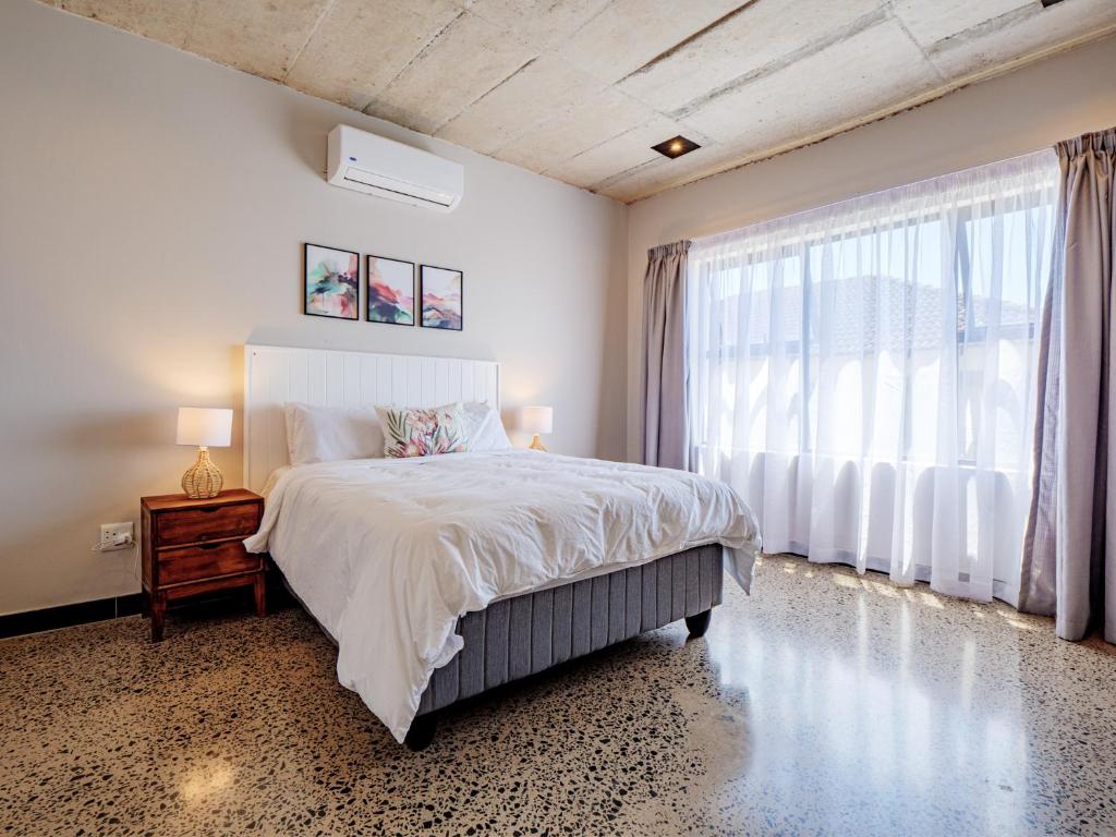 a bedroom with a bed and a large window at The Lofts on Manaar in Durban