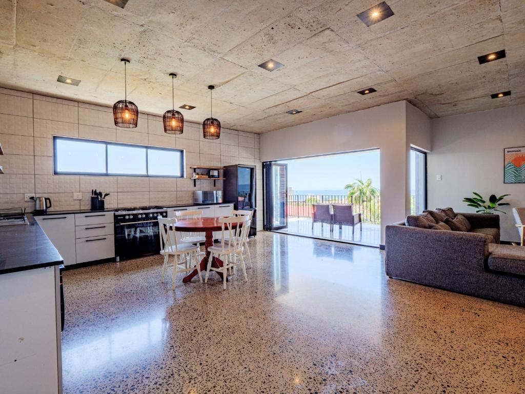 a kitchen and living room with a table and a couch at The Lofts on Manaar in Durban