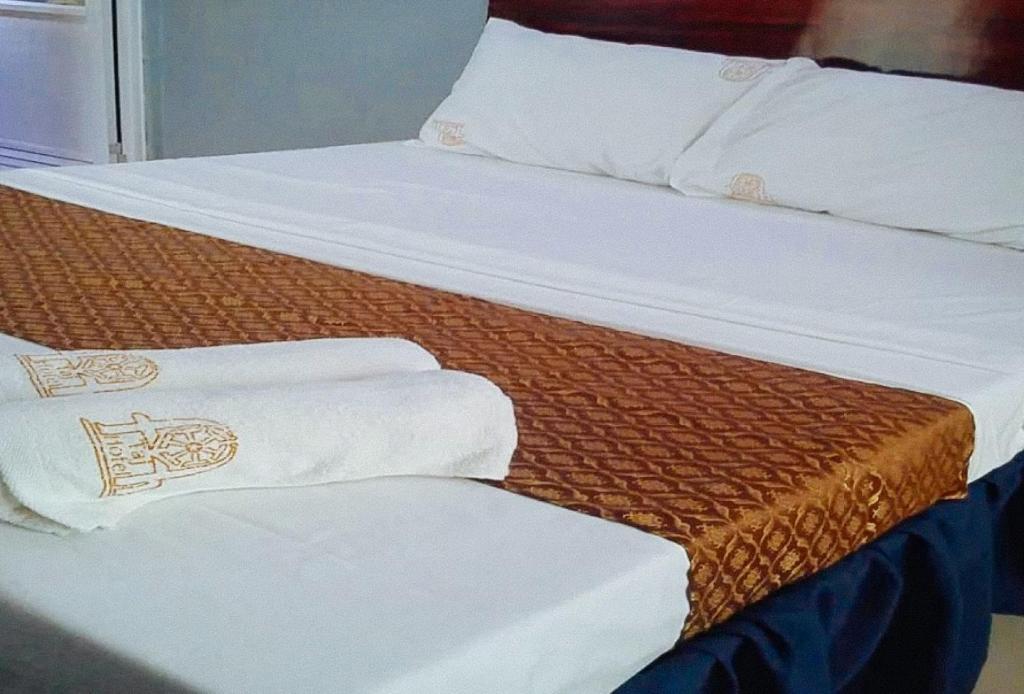 Postel nebo postele na pokoji v ubytování RedDoorz Plus @ Taj Hotel Tuguegarao