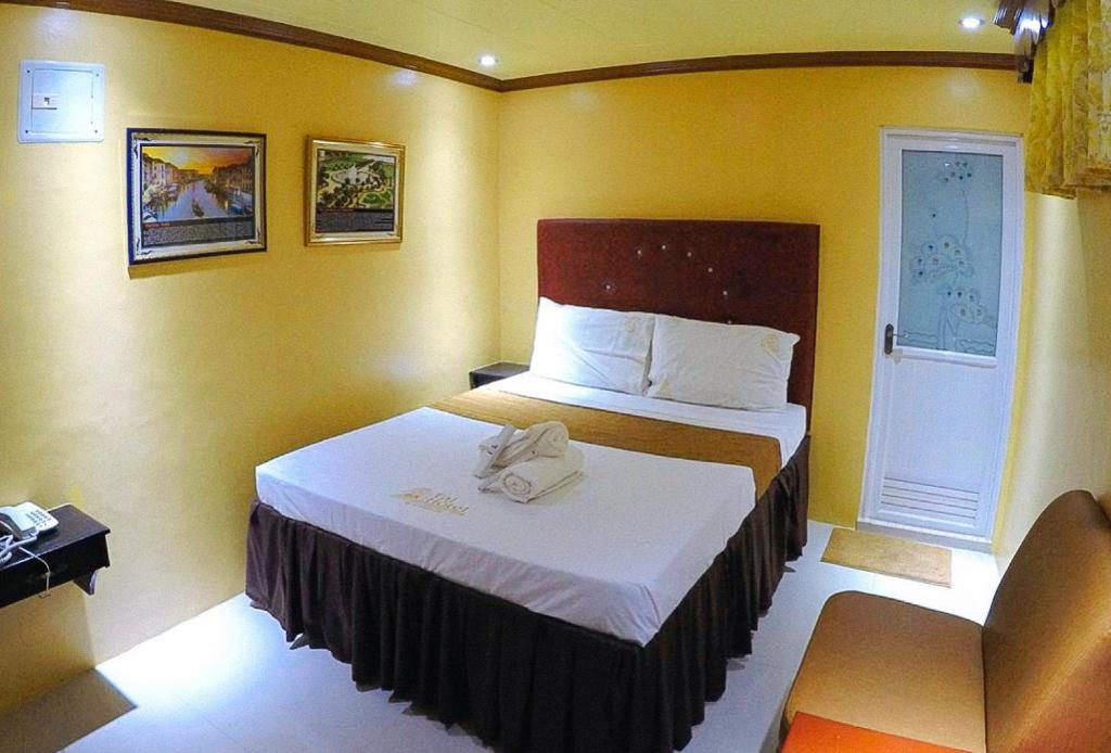 Postel nebo postele na pokoji v ubytování RedDoorz Plus @ Taj Hotel Tuguegarao