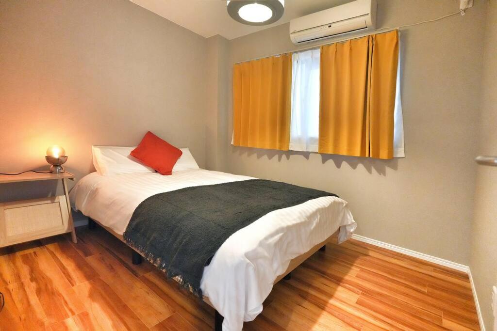 a bedroom with a bed with a red pillow at ZJ202 Hanama202 The Skytree Residence A Newly Home by Tokyo Iconic Landmarks in Tokyo