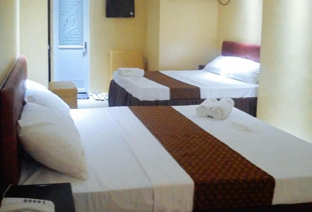 Postel nebo postele na pokoji v ubytování RedDoorz Plus @ Taj Hotel Tuguegarao