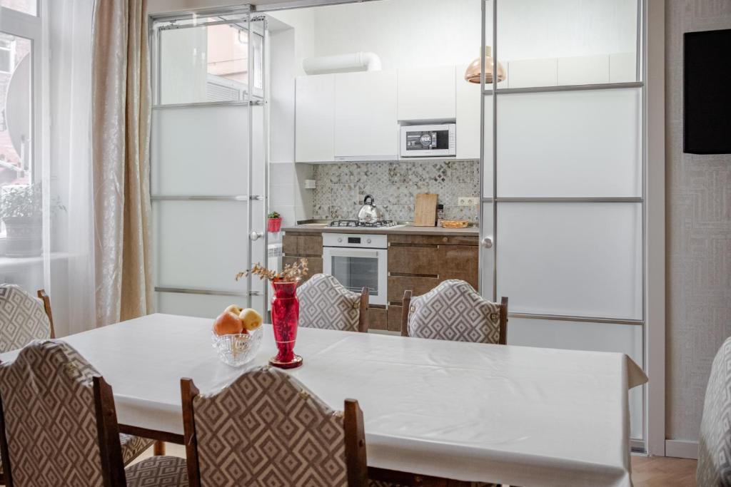 トビリシにあるGuest Home in the Heart of old Tbilisi centerの白いテーブルと椅子のあるキッチンとダイニングルーム