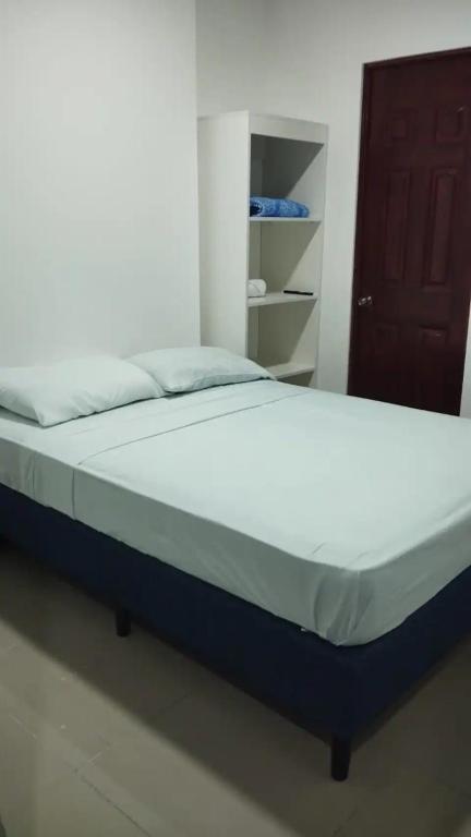 a bed sitting in a room with a door at Pura Vida in San José