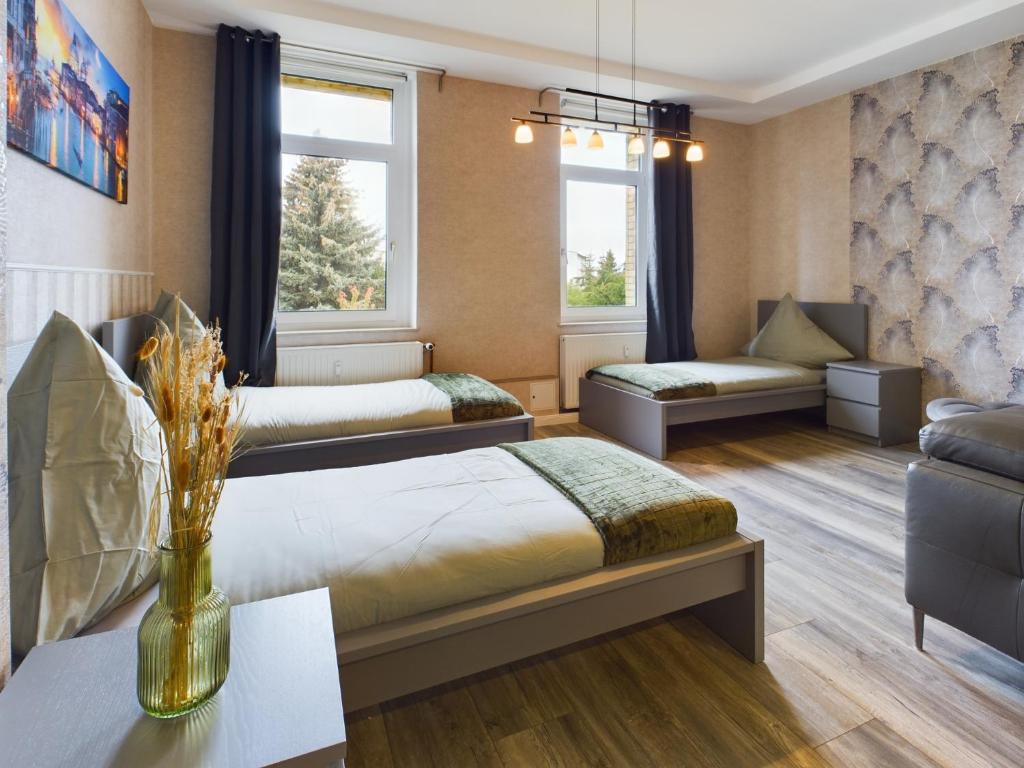 a hotel room with two beds and a couch at OtterslebenGartenblick37 - Küche & Garten, bis zu 3 Personen in Magdeburg