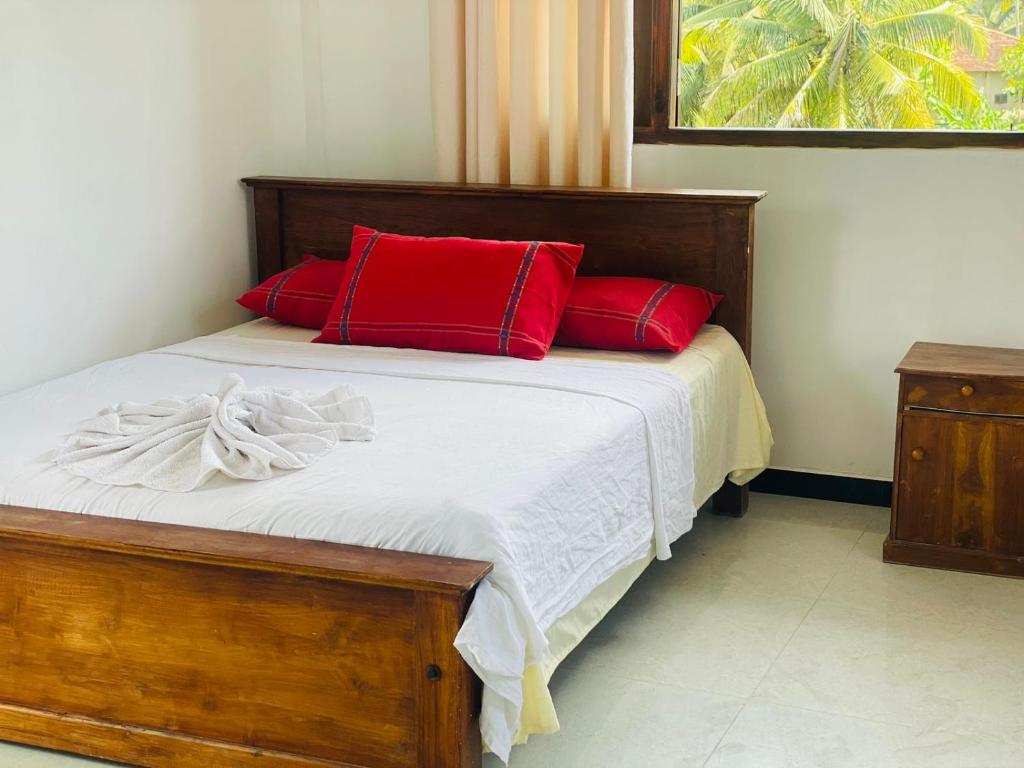 a bedroom with a bed with red pillows at Relax House Water Villa in Rathgama
