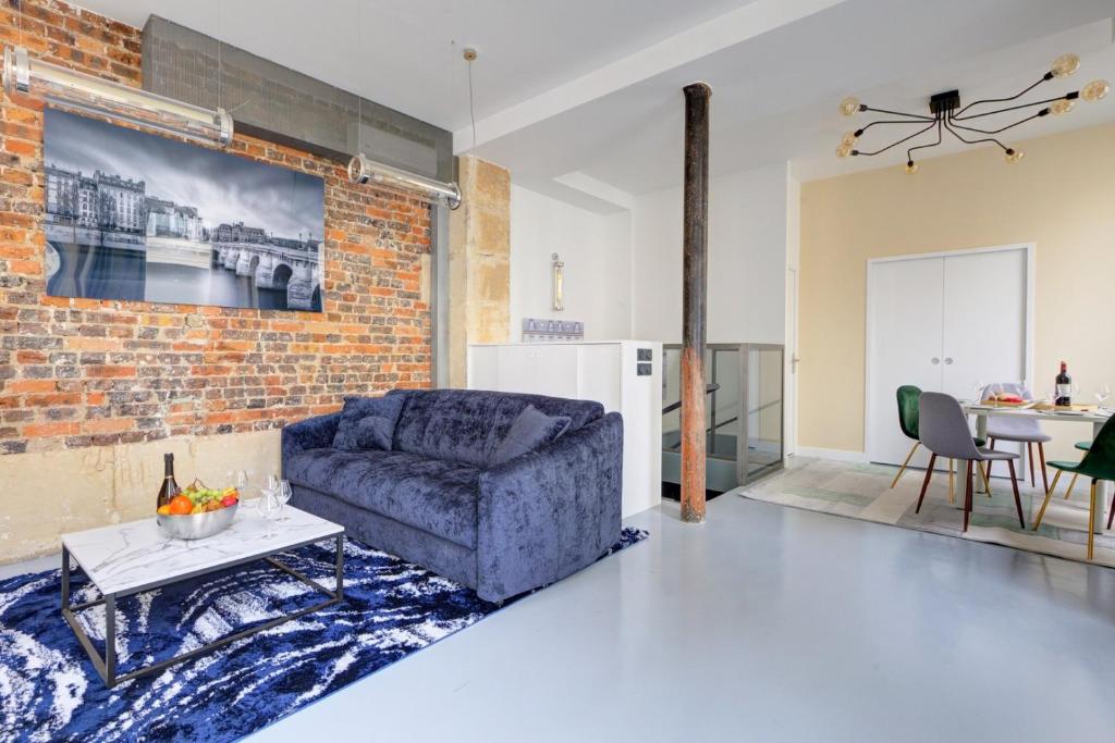 un salon avec un canapé et un mur de briques dans l'établissement Bluestay 299 - Superb apartment in Paris, à Paris