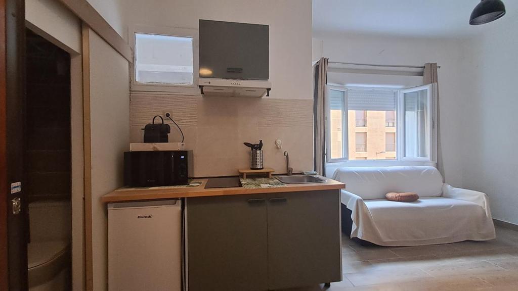 - une cuisine avec évier et un lit dans une chambre dans l'établissement Studio au cœur du vieux port, à Marseille