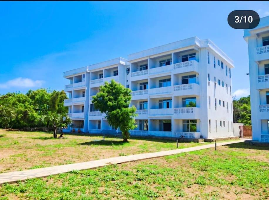 an apartment building with a tree in front of it at Daffi giraffi House in Malindi
