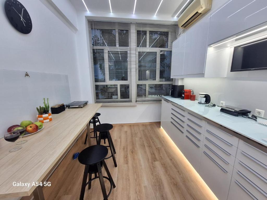 a kitchen with white cabinets and a wooden counter top at AS luxury apartment in Athens