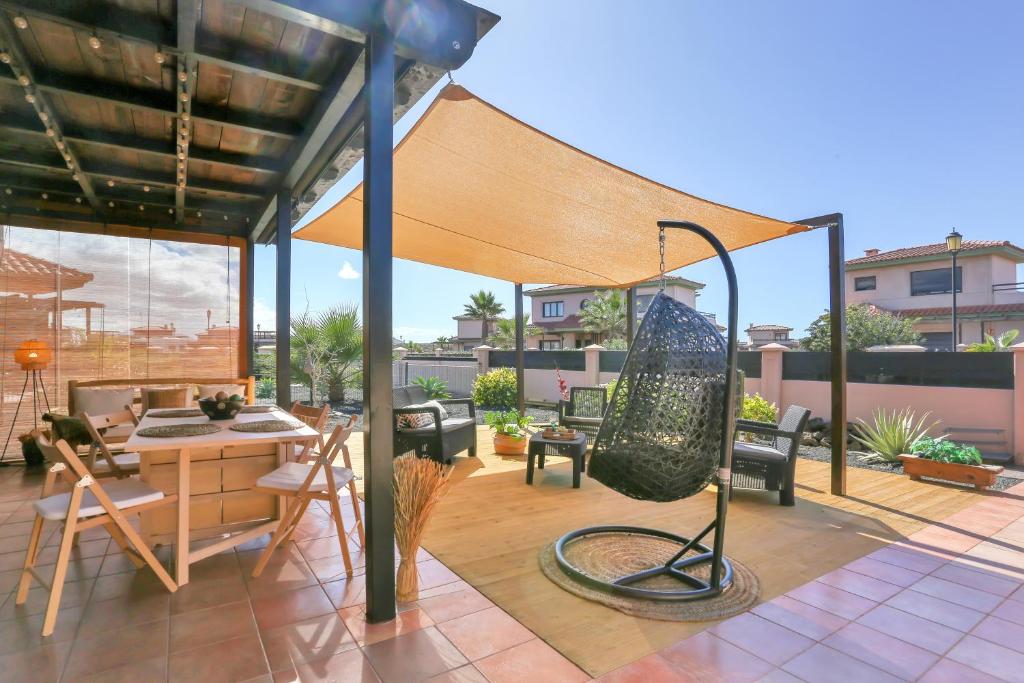 a patio with an umbrella and a table and chairs at La Torre del Mar, rincón del Atlántico Lajares- Origomare - Remote work in Lajares