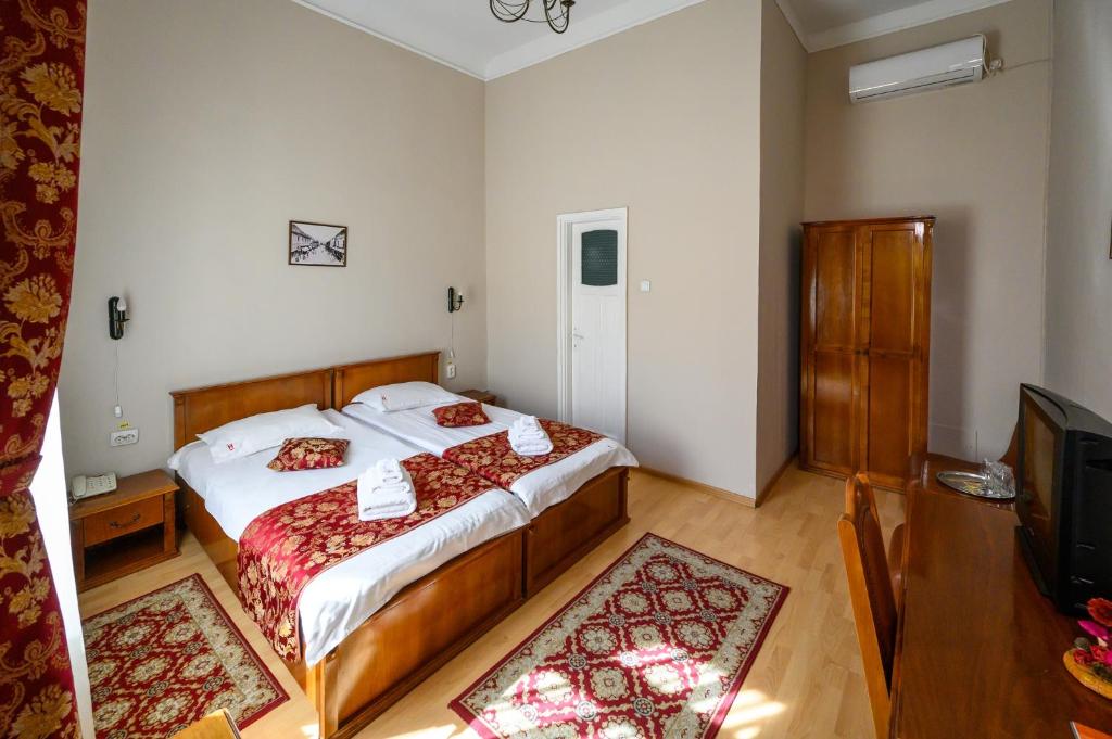 a bedroom with a large bed and a television at Hotel Transilvania in Cluj-Napoca
