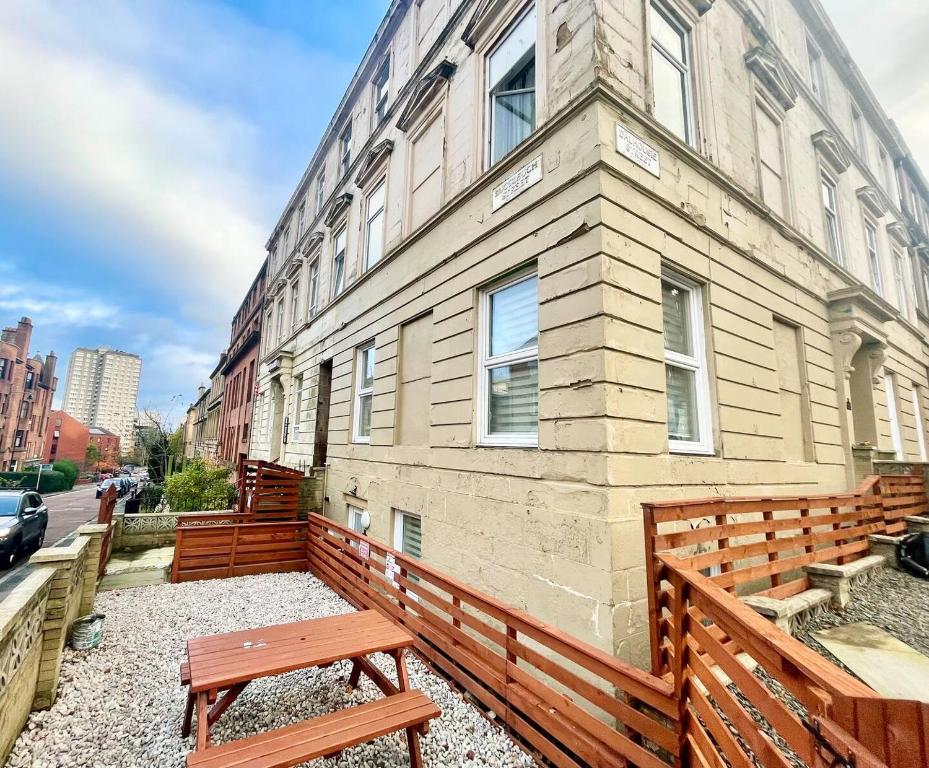 a wooden bench in front of a building at City Gem Main Door Parking Pass the Keys in Glasgow