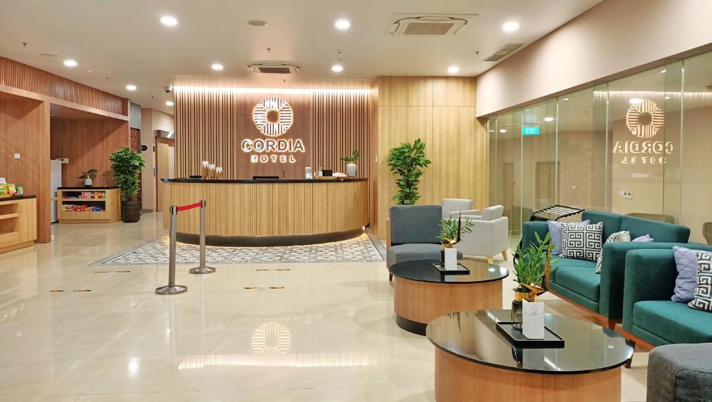 a lobby of a hotel with blue couches and a counter at Cordia Hotel Yogyakarta - Hotel Dalam Bandara in Glagah
