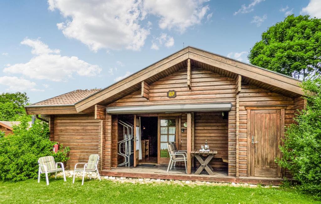 eine Blockhütte mit Tisch und Stühlen im Hof in der Unterkunft Ferienhaus Erms 87 in Hayingen