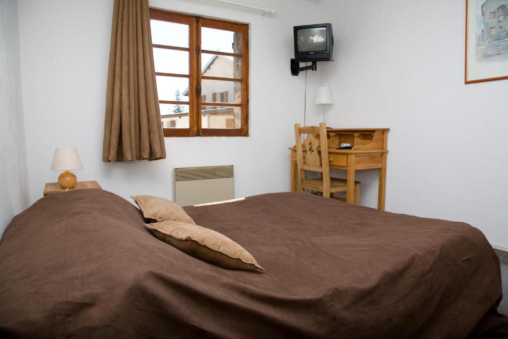 een slaapkamer met een groot bed en een raam bij Adonis Le Chastellan in Valberg