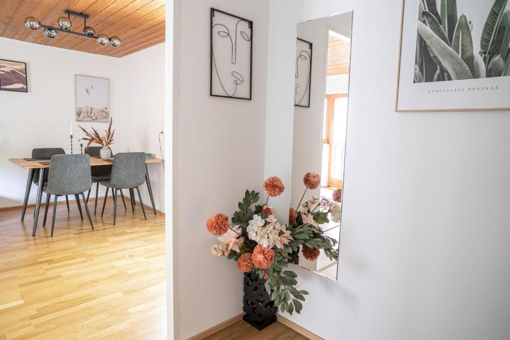 salon ze stołem i wazą z kwiatami w obiekcie FarawayHomes Studio St Wolfgang #4 w mieście Ried