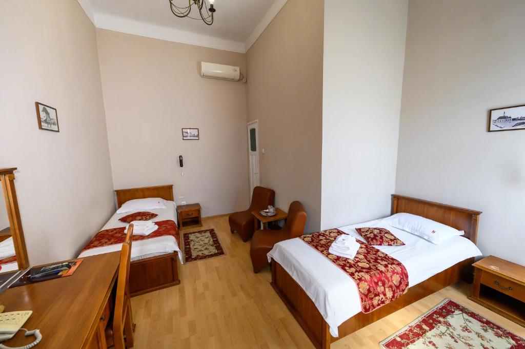a hotel room with two beds and a desk at Hotel Transilvania in Cluj-Napoca