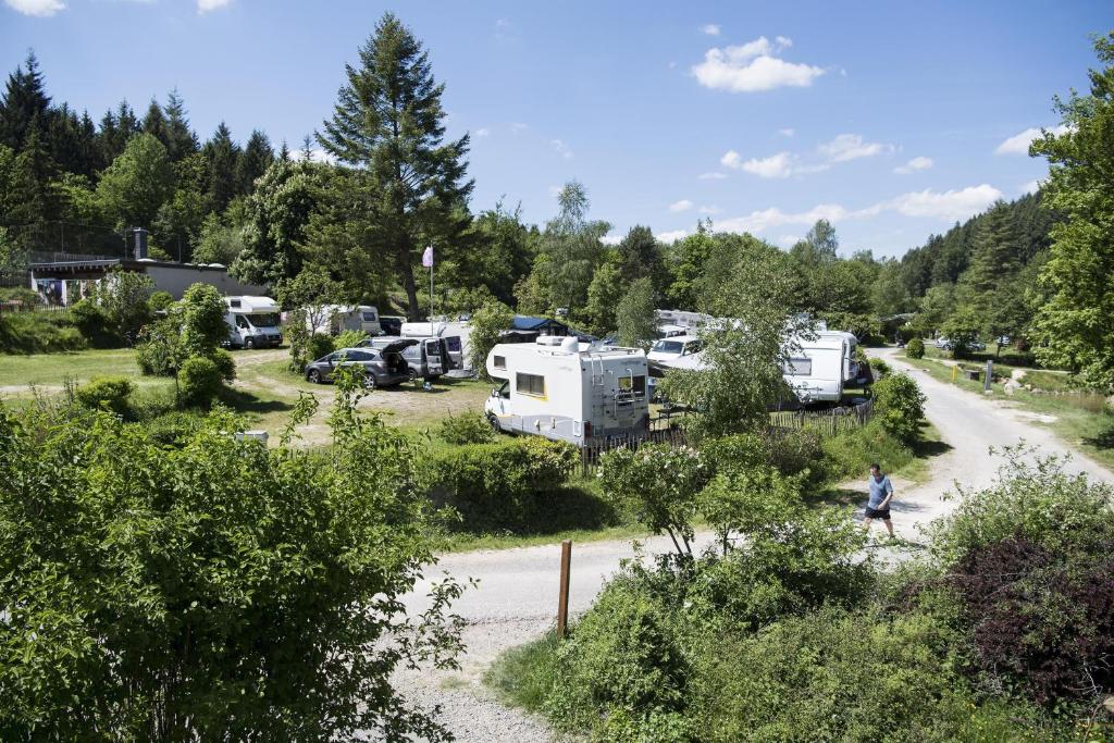 a man walking down a road next to a campsite at Harfenmühle Camping in Mörschied
