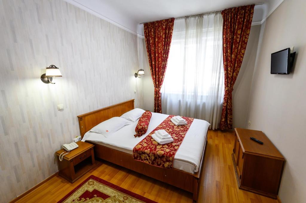 a hotel room with a bed and a window at Hotel Transilvania in Cluj-Napoca