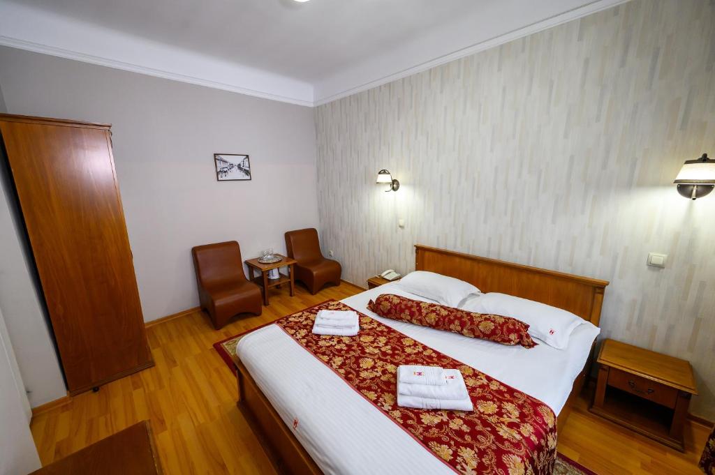 a hotel room with a bed with two towels on it at Hotel Transilvania in Cluj-Napoca
