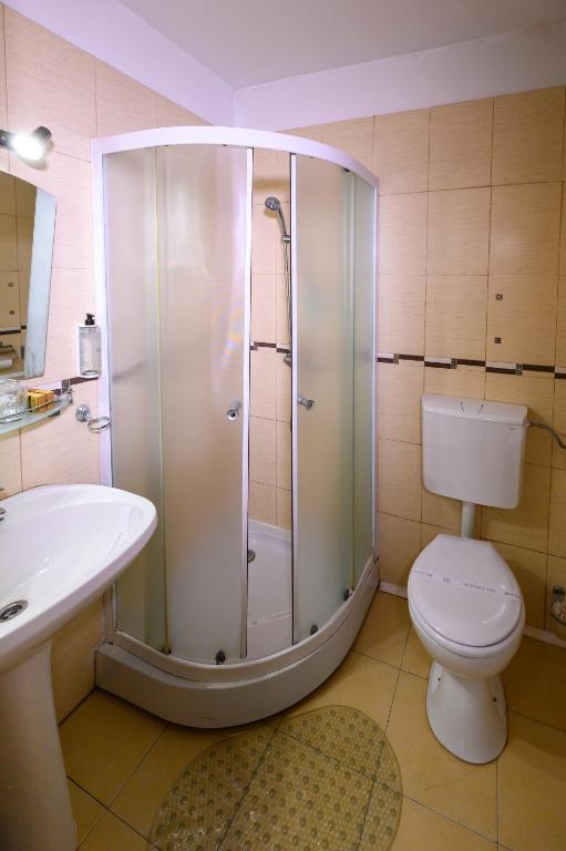 a bathroom with a shower and a toilet and a sink at Hotel Transilvania in Cluj-Napoca