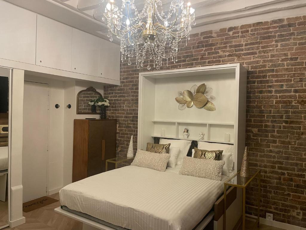une chambre avec un lit dans un mur de briques dans l'établissement Paris Montorgueil Seng, à Paris