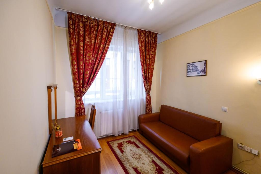 a living room with a couch and a window at Hotel Transilvania in Cluj-Napoca