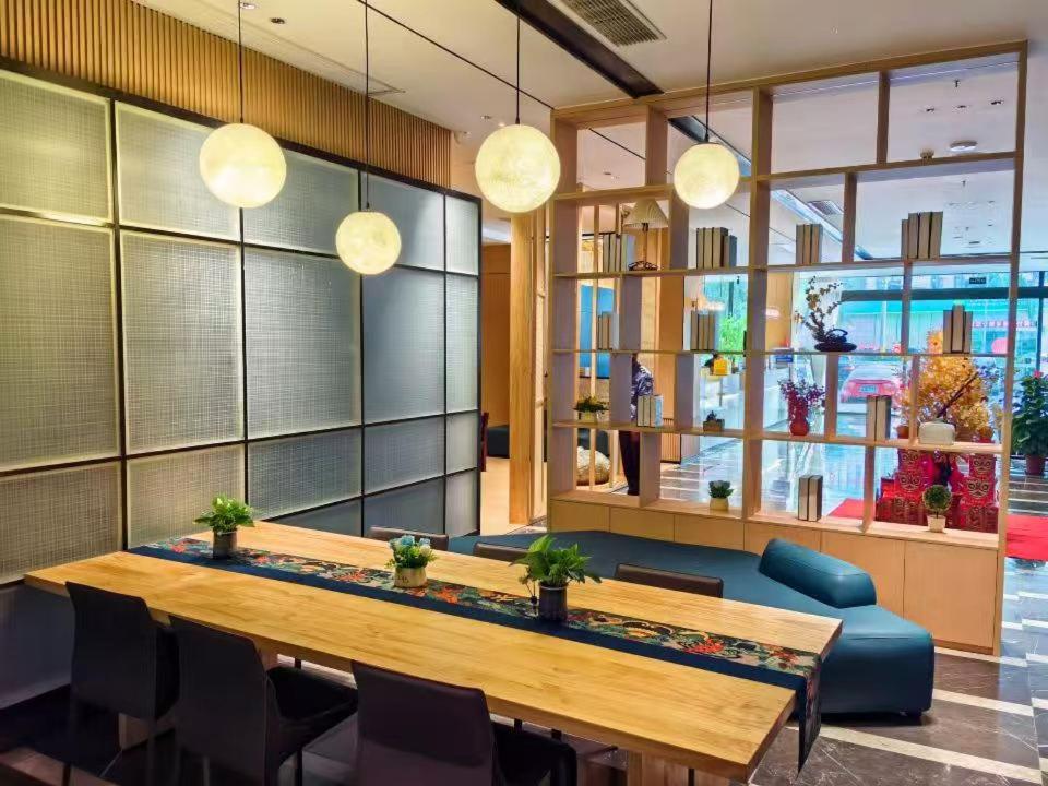 a conference room with a table and chairs and lights at 宜尚酒店 日月广场骑楼老街店 in Haikou