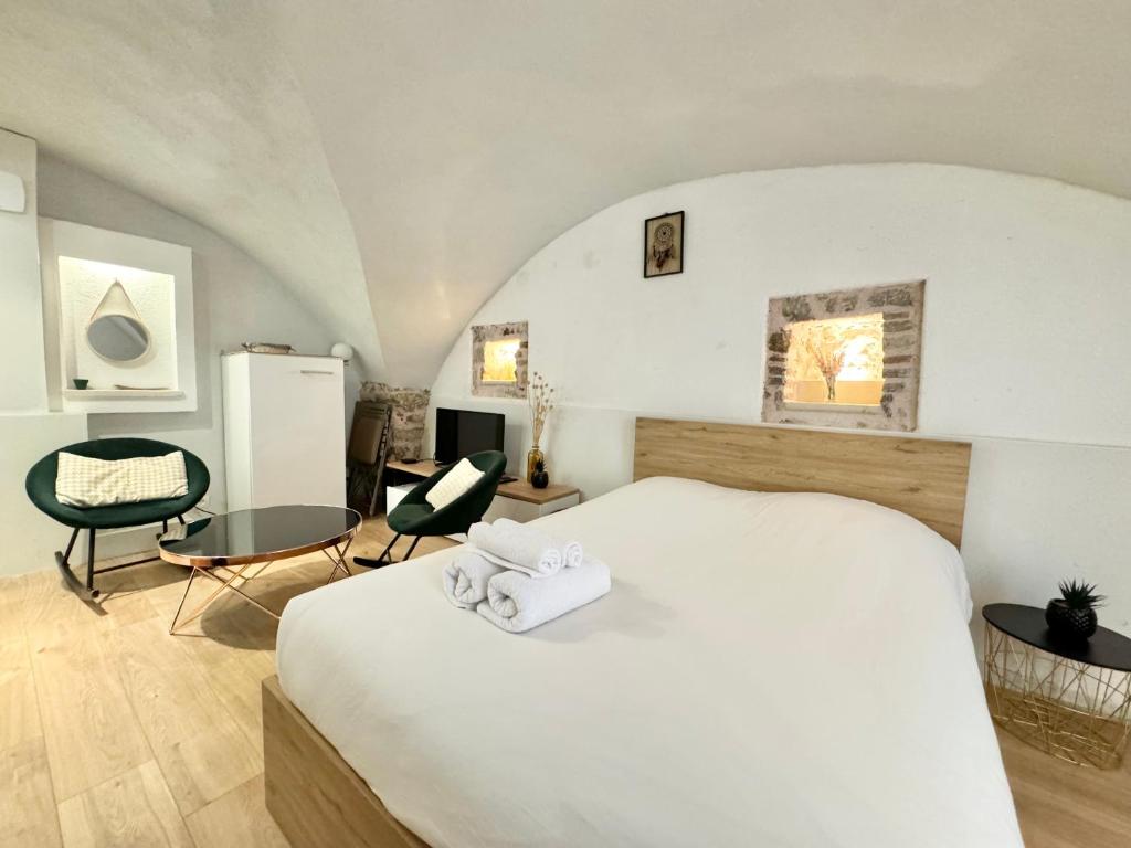 une chambre avec un grand lit blanc avec deux serviettes dans l'établissement Studio Vieil Antibes rue du Bateau, à Antibes
