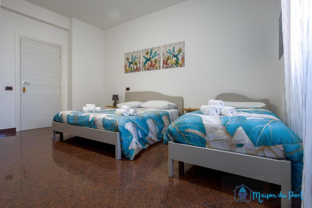 twee bedden naast elkaar in een slaapkamer bij Maison du Port in Civitavecchia