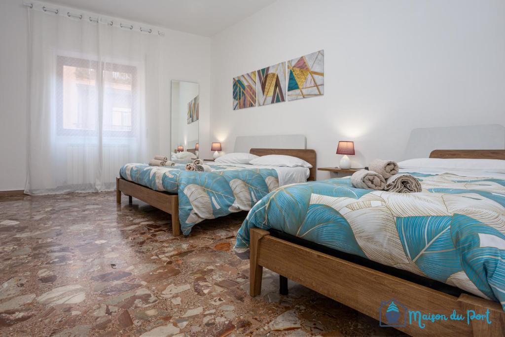 a bedroom with two beds and a window at Maison du Port in Civitavecchia