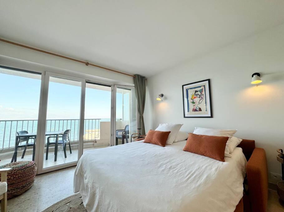 une chambre avec un grand lit et un balcon dans l'établissement La petite Grenille, à Antibes