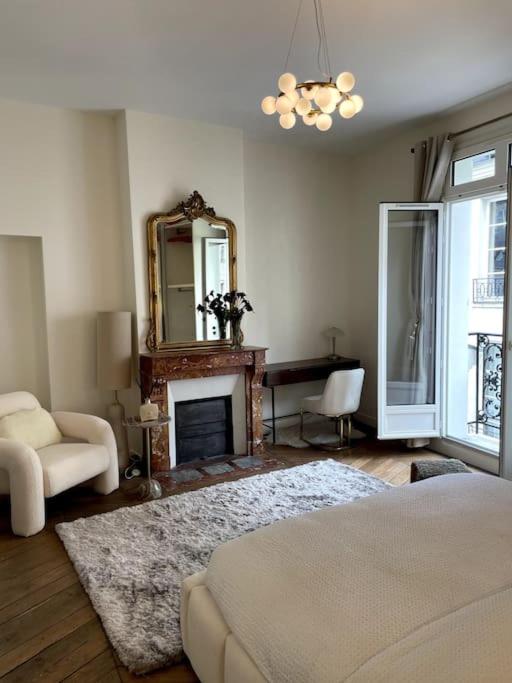 un salon avec une cheminée et un miroir dans l'établissement Paris Luxury Family Getaway, à Paris