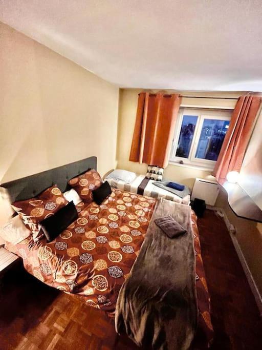 une chambre avec un grand lit et deux fenêtres dans l'établissement Eiffel Tower, à Paris