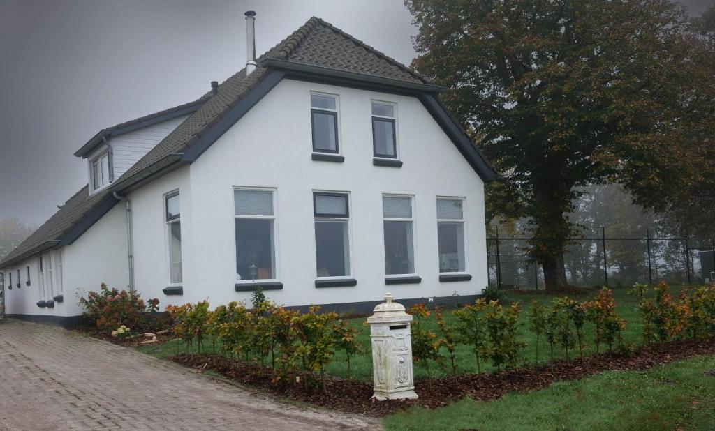 a white house with a fire hydrant in front of it at Bed & breakfast by Patty in Nieuw-Amsterdam