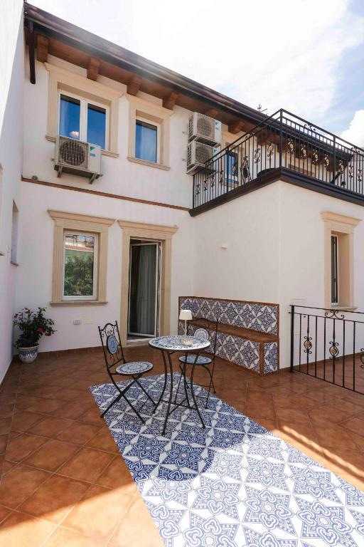 a patio with a table and chairs and a balcony at TEA Luxury - Praia a Mare in Praia a Mare
