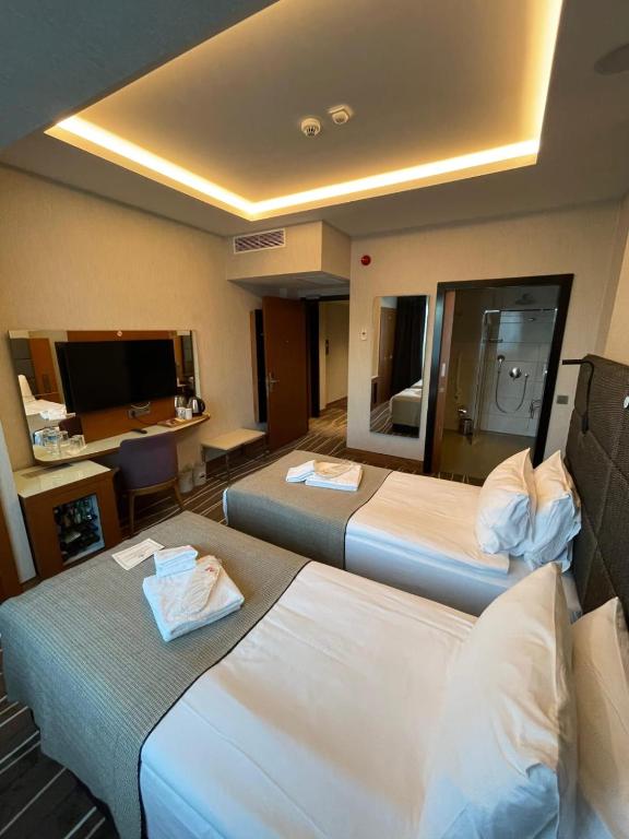 a hotel room with two beds and a desk at Cihangir Hotel Bosphorus in Istanbul