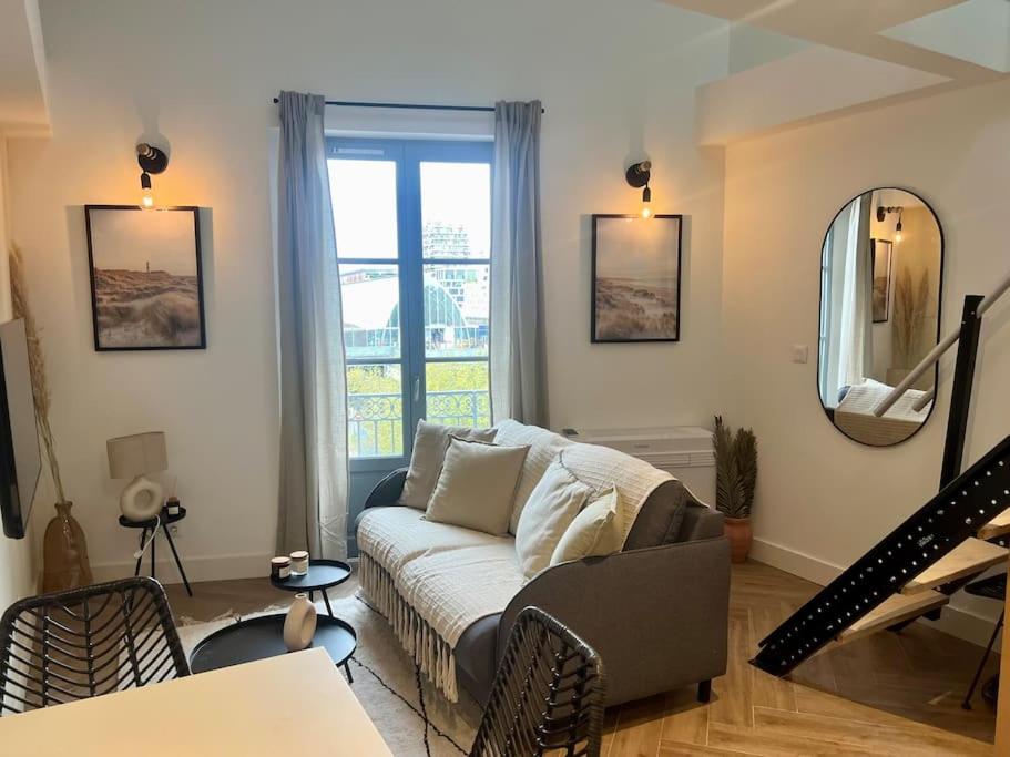 un salon avec un canapé et une fenêtre dans l'établissement Casaflora - Le Corner Montpellier, à Montpellier