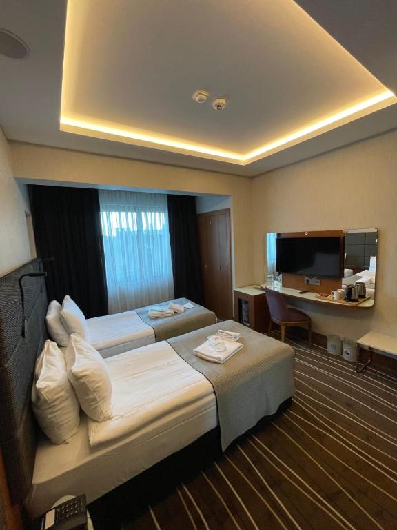 a hotel room with two beds and a desk at Cihangir Hotel Bosphorus in Istanbul