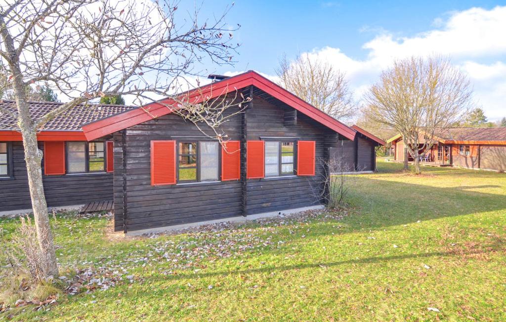 a house with red shutters on it in a yard at Ferienhaus Neckar 68 in Hayingen