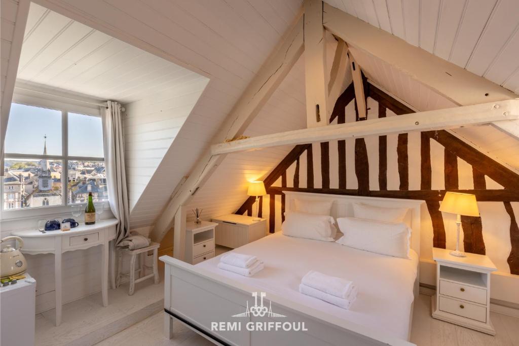 - une chambre avec un grand lit blanc et un lavabo dans l'établissement Dolphin view - studio - Cozy nest with a view of the port, à Honfleur