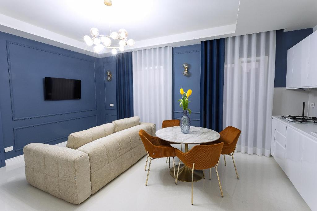 ein Wohnzimmer mit einer Couch und einem Tisch und Stühlen in der Unterkunft Luxury apartment-Corso Malta by Alux38 in Neapel