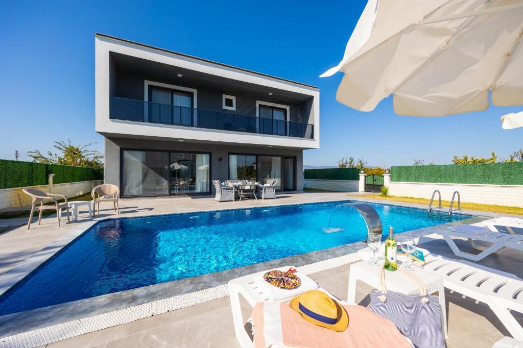 a villa with a swimming pool and a house at Villa Grand Yasar 3 in Okçular