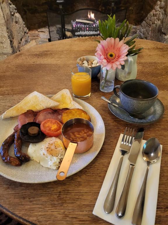 a plate of breakfast food on a wooden table at The Colesbourne Inn in Colesbourne
