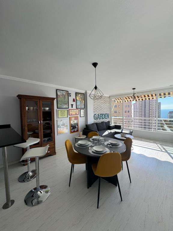 a dining room with a table and chairs and a couch at El Apartamento de Cristian 4 in Benidorm