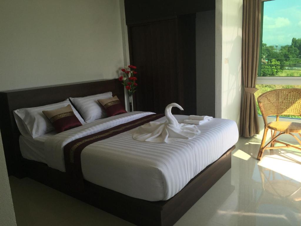 Un dormitorio con una cama grande con un cisne. en หมื่นช้างน่านบูทีคHotel, en Nan