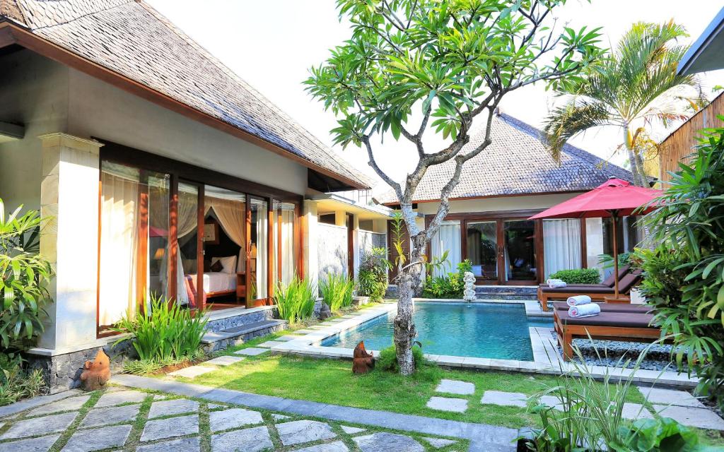 a house with a swimming pool next to a house at The Sanyas Suite Bali in Seminyak